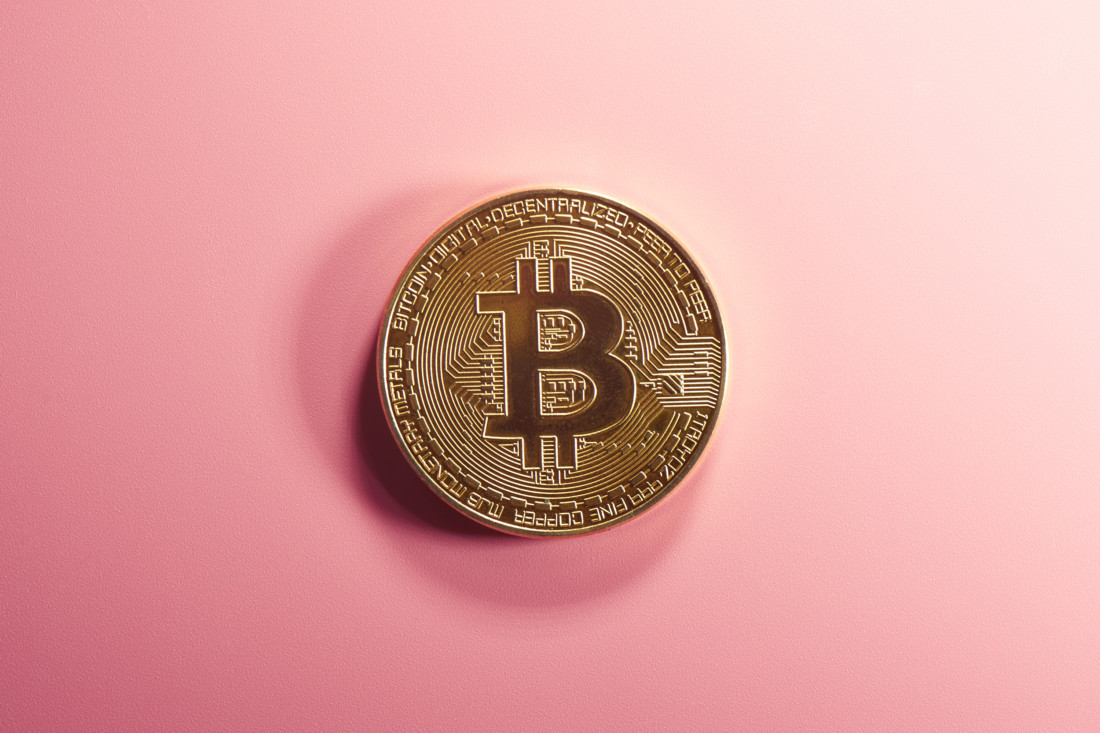 монета биткоина на розовом фоне