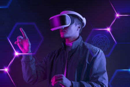 человек в VR очках трогает виртуальный экран на темно-фиолетовом фоне